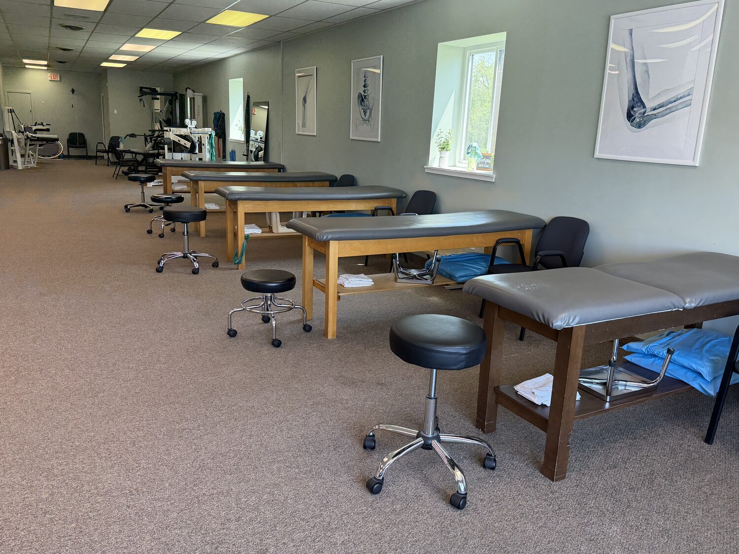 Row of treatment tables along the clinic's sunny window wall